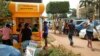 FILE - Ugandans use a mobile money point in Kampala, Uganda, Sept. 29, 2016. The country's Financial Intelligence Authority, set up to track illicit money flows, says it lacks resources to stop them.