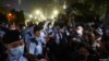 La gente mira a los oficiales de policía que hacen guardia en el Parque Victoria en el 32 aniversario de la represión de los manifestantes a favor de la democracia en la Plaza de Tiananmen de Beijing en 1989, en Hong Kong, el 4 de junio de 2021.