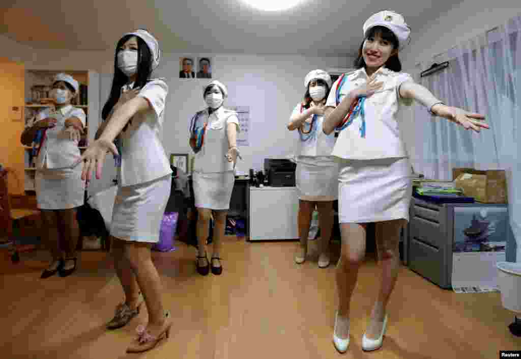 日本的一个名叫“先军女郎”的朝鲜粉丝小组的成员在东京练习舞蹈(2017年10月29日)。朝鲜今年一再向日本海域发射导弹,两国关系紧张。但在日本的这个女团,穿着军装,模仿朝鲜牡丹峰乐团 的歌舞。生活中,她们也热衷朝鲜文化和艺术。日本的韩裔社区对她们褒贬不一。套用古诗来说,歌女不知专制恨,隔海犹学“牡丹峰”?