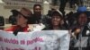 ARCHIVO - Manifestantes sostienen un cartel contra el expresidente Sánchez de Lozada en una protesta en La Paz, Bolivia, 2012.