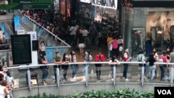 Personas hacen fila para entrar a tiendas de ropa con ofertas de Black Friday en un centro comercial en el este de Caracas, el 20 de noviembre de 2020.