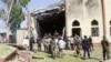 Soldiers stand guard outside St. Rita's Catholic church following a suicide bombing, Kaduna, Nigeria, Oct. 28, 2012.