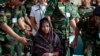 Reshma Begum, center, the 19-year-old seamstress who spent 17 days trapped in the rubble of a collapsed factory building talks to the media at a hospital in Savar, near Dhaka, Bangladesh, May 13, 2013. 
