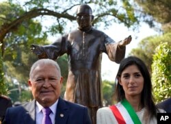El presidente El Salvador, Salvador Sánchez Cerén (izq.) y la alcaldesa de Roma Virginia Raggi, posan juntos tras develar una estatua del asesinado obispo salvadoreño Óscar Arnulfo Romero, el sábado 13 de octubre de 2018, un día antes de que Romero fuera elevado a la santidad.
