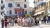 Tourists at the medina in Tunis are flanked by campaign posters, Sept. 13, 2019. (L. Bryant/VOA) 