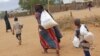 A newly arrived Somali family carry their supply of aid outside Dadaab, Eastern Kenya, 100 kms (60 miles) from the Somali border, Aug. 5, 2011. (AP)