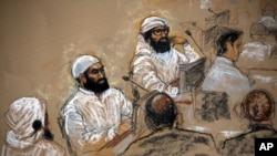 In this courtroom sketch, alleged 9/11 co-conspirators, left, sit with their legal teams during a hearing in the Camp Justice compound for the U.S. war crimes commission on Guantanamo Bay U.S. Naval Base in Cuba, July 16, 2009. 