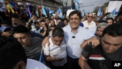 El candidato presidencial Carlos Pineda (centro) del partido Prosperidad Ciudadana sale de la Corte Constitucional en la Ciudad de Guatemala, el sábado 20 de mayo de 2023. Pineda busca revertir una decisión judicial que lo excluyó del proceso electoral. (Foto AP/Moisés Castillo)
