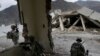 In this Tuesday, Nov. 3, 2009 photo, U.S. soldiers from the 2nd Battalion, 12th Infantry Regiment, 4th Brigade Combat Team, 4th Infantry Division wait inside a destroyed health clinic in the village of Qatar Kala in the Pech Valley of Afghanistan.