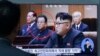 A man at South Korea's Seoul Railway Station views a TV screen showing file footage of North Korean leader Kim Jong Un, in foreground, with education official Kim Yong Jin, second from left.