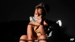 Una niña de Chandler, Arizona, utiliza un teléfono inteligente desde su casa el 16 de junio de 2023.