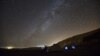 FILE - A meteor streaks across the sky in the early morning as people watching during the Perseid meteor shower in Ramon Carter near the town of Mitzpe Ramon, southern Israel, August 13, 2015. The Perseid meteor shower is sparked every August when the Earth passes through a stream of space debris left by comet Swift-Tuttle.