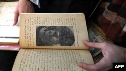 A member of the Kurdistan Centre for Arts and Culture, inspects an old book before making a digital copy, as part of an effort to digitize historic Kurdish volumes and manuscripts, in the northern Iraqi city of Dohuk on February 13, 2024.