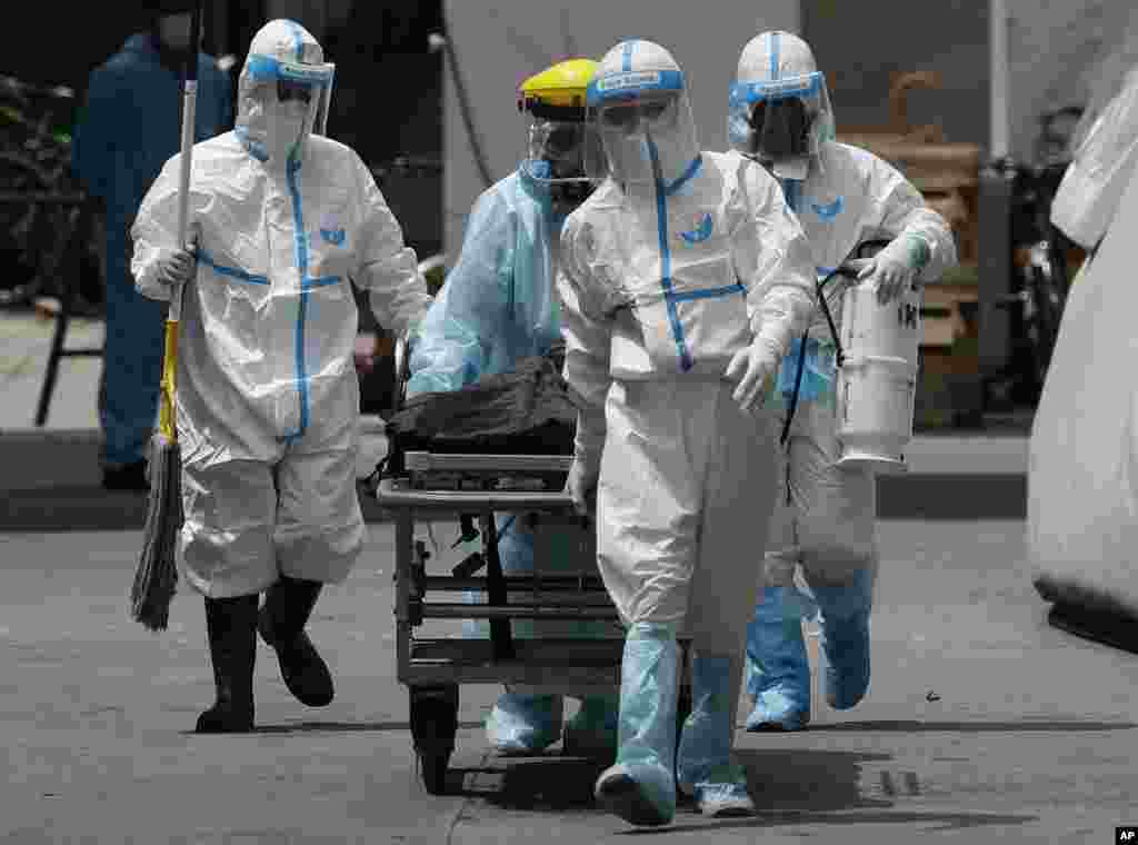 Health workers in protective suits transport a dead body at a hospital in Manila, Philippines.&nbsp;The capital and outlying provinces returned to another lockdown after medical groups warned that the country was waging a losing battle against the coronavirus.&nbsp;