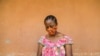 FILE - A woman checks her phone in Yaounde, Cameroon, April 23, 2020. An International Crisis Group report has found hate speech spread through social media to be a major contributor to ethnic and political tensions in the country. 