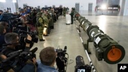 FILE - Foreign military attaches and journalists attend a briefing by the Russian Defense Ministry as a land-based cruise missile, right, is displayed in Kubinka outside Moscow, Russia, Jan. 23, 2019. The Russian military said the new weapon does not violate the INF Treaty.
