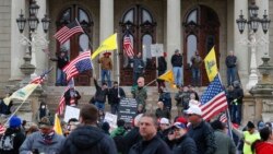 Manifestantes protestan en la escalinata del capitolio estatal de Michigan, en Lansing, la capital del estado, el miércoles 15 de abril de 2020.