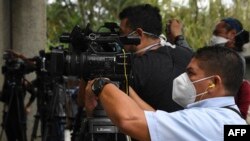 Un camarógrafo usa una mascarilla quirúrgica durante una conferencia de prensa en San Salvador el 21 de abril de 2020.