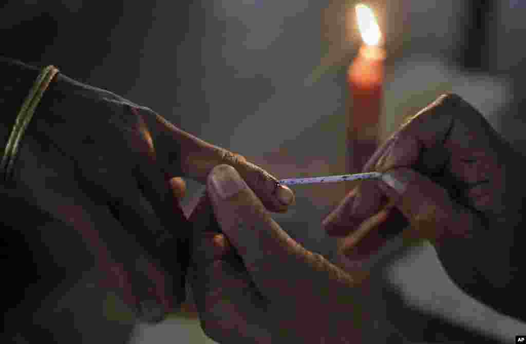 An Indian election official applies an indelible ink mark on the finger of a Mishing tribal woman voter during the first phase of elections at Misamora Sapori, an island in northeastern Assam state, India, April 7, 2014. 