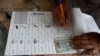 An election worker prepares ballot paper for a tribesman, waiting to cast his vote in a polling station during an election for provincial seats in Jamrud, a town of Khyber district, Pakistan, Saturday, July 20, 2019.