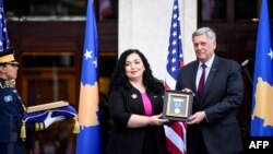 Президентка Вйоса Османі передає послу США Філіпу Коснетту посмертну медаль Бо Байдену, 1 серпня 2021