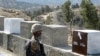 FILE - A Pakistani soldier stands guard at a border fence between Pakistan and Afghanistan, at Angore Adda, Pakistan, Oct. 18, 2017.