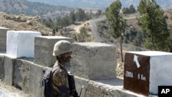 FILE - A Pakistani soldier stands guard at a border fence between Pakistan and Afghanistan, at Angore Adda, Pakistan, Oct. 18, 2017.