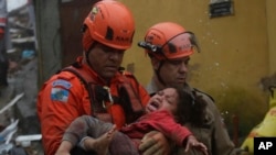 Los rescatistas cargan a una niña de 4 años que fue rescatada de su casa derrumbada después de fuertes lluvias en Petrópolis, estado de Río de Janeiro, Brasil, el sábado 23 de marzo de 2024.