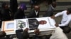 Unas personas cargan el ataúd del director de misiones Judes Montis, quien fue asesinado por miembros de una pandilla junto con dos misioneros de Estados Unidos, luego de su funeral en Puerto Príncipe, Haití, el martes 28 de mayo de 2024. 