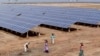 Indian laborers work near solar panels at the Gujarat Solar Park at Charanka in Patan district, about 250 kilometers (155 miles) from Ahmadabad, India, Apri. 14, 2012. 