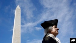 ARCHIVO - John Lopes, interpretando el papel del presidente George Washington, se encuentra cerca del Monumento a Washington después de una ceremonia de inauguración con la primera dama Melania Trump para reabrir el monumento, el 19 de septiembre de 2019, en Washington.