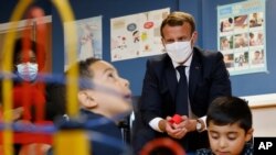 El presidente francés Emmanuel Macron observa a unos niños jugar durante una visita a un centro de cuidado infantil en Longjumeau, sur de París, el miércoles 23 de septiembre de 2020.