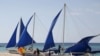 FILE - Tourists takes photographs along local sailboats on the island of Boracay, central Philippines, Jan. 18, 2016. 