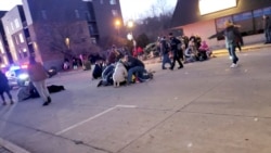 Transeúntes prestan asistencia a las personas lesionadas cuando un vehículo embistió a un desfile navideño en Waukesha, Wisconsin, el 21 de noviembre de 2021.