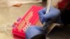 FILE - A researchers works with coronavirus samples as a trial begins on whether the anti-malaria drug hydroxychloroquine can prevent or reduce the severity of COVID-19, at the University of Minnesota in Minneapolis, Minnesota, March 19, 2020.