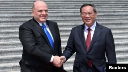 El primer ministro ruso, Mikhail Mishustin, a la izquierda, y el primer ministro chino, Li Qiang, asisten a una ceremonia de bienvenida en Beijing, China, el miércoles 24 de mayo de 2023.
