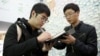 FILE - Student leader Alex Chow, (L) who took part in Hong Kong's Occupy Central or the so-called "Umbrella" movement, signs an autograph for a student from mainland China at Taiwan's Democratic Progressive Party (DPP) headquarters in Taipei, Taiwan, Jan. 14, 2016.
