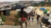Rohingya refugees walks along the refugee camp during rain in Cox’s Bazar, Bangladesh, July 25, 2018.