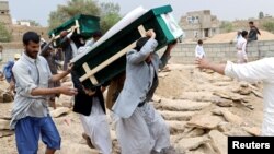FILE - Mourners carry coffins during a funeral of people, mainly children, killed in a Saudi-led coalition airstrike on a bus in northern Yemen, in Saada, Yemen, Aug. 13, 2018. 