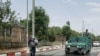 FILE - Afghan policemen stand guard at the gate of one of Kabul's universities, June 4, 2018.