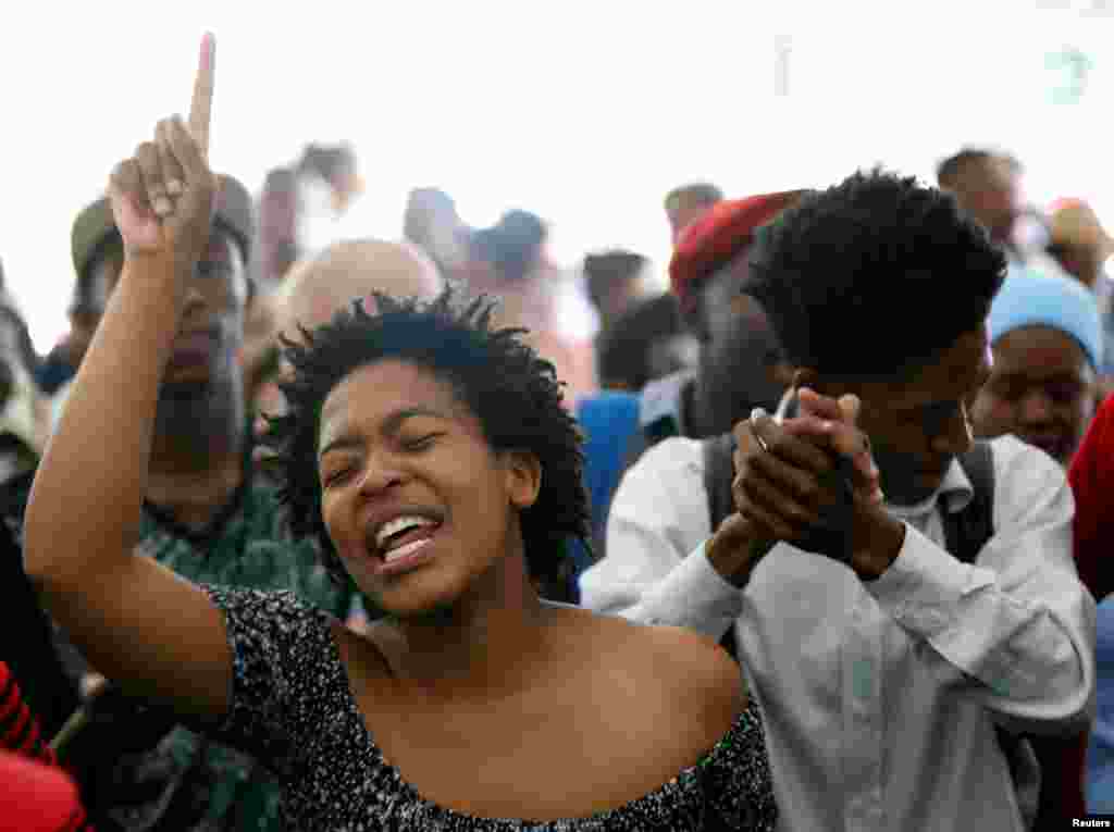 Para siswa menyanyikan lagu-lagu perjuangan selama sebuah pertemuan dimana staf akademik dan para pemimpin gereja berunjuk rasa untuk menuntut pendidikan tertier gratis di Johannesburg University di Witwatersrand, Afrika Selatan.