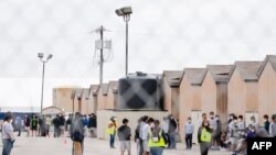 Al fondo jóvenes migrantes dentro del campo petrolífero de Cotton Logistics que se construyó en 2012 para albergar temporalmente a los trabajadores de la industria petrolera en Midland, Texas, el 5 de abril de 2021.