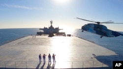 Esta imagen tomada de un video publicado el miércoles 13 de enero de 2021 por el ejército iraní muestra un helicóptero aterrizando en el buque logístico Makran durante un simulacro de la marina. [Foto del ejército iraní vía AP]