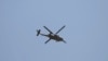 A U.S. military helicopter flies over the site of a suicide car bomb in Kabul, Afghanistan, Friday, May 31, 2019.