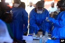 Healthcare workers from the World Health Organization prepare to give an Ebola vaccination to a front line aid worker in Beni Democratic Republic of Congo, Aug 10, 2018.