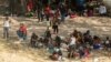Migrantes solicitantes de asilo descansan a la sombra cerca del Puente Internacional entre México y Estados Unidos, donde los migrantes solicitantes de asilo esperan ser procesados en Del Rio, Texas, EE. UU., el 15 de septiembre de 2021.