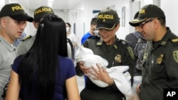 Policías colombianos llevan al hospital a una recién nacida abandonada descubierta junto a un auto cerca de un estadio en Cúcuta, Colombia. Una nota encontrada junto a la bebé dice que la niña se llama Ángela y que la madre no tiene medios para cuidarla. Foto AP, cortesía de la Policía Nacional de Colombia.