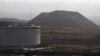 ARCHIVO - Un montículo de coque se ve junto a un tanque de petróleo en el complejo industrial José Antonio Anzoátegui de PDVSA en el estado de Anzoátegui, en Venezuela, el 15 de abril de 2015