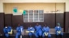 FILE - Health workers rest outside a quarantine zone at a Red Cross facility in the town of Koidu, Kono district in Eastern Sierra Leone, Dec. 19, 2014. 