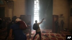 Palestinos dentro de la mezquita de al-Aqsa se enfrentan a la policía israelí en la Ciudad Vieja de Jerusalem, el 10 de mayo del 2021.